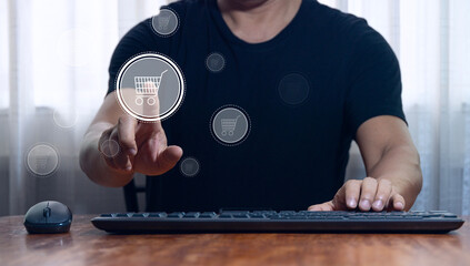 Businessman pressing a shopping cart icon with computer keyboard online shopping concept