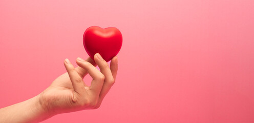 Adult hands giving a red heart, health care, organ donation, family life insurance, world heart...