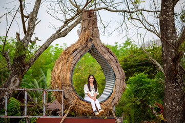 Enchanting Tree House Retreat: Woman on Circular Chair Amidst Nature's Splendor