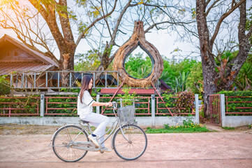 Asian woman riding a bicycle on road