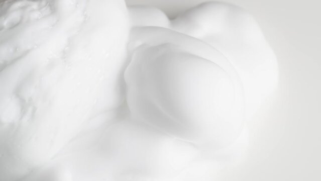 Hair foam mousse, macro. Beauty background. Close up of white cloud of hair mousse or shaving foam.