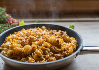 Creamy beef pasta and cheese fresh cooked in a hot and steaming frying pan