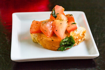 Colorful appetizer in white tray on black table