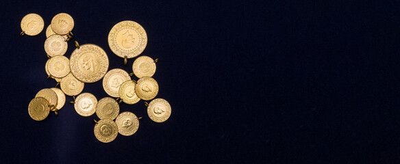 The pile of full, half and quarter Turkish gold coins on a dark navy blue background