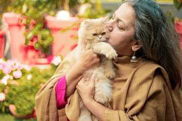 Indian senior woman with cat at home