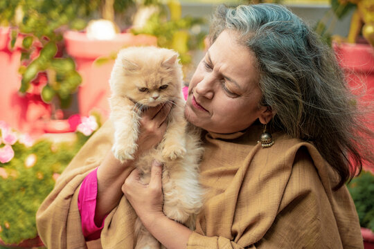 Indian senior woman with cat at home