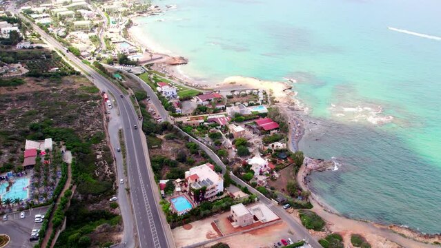 Slow motion aerial view of the coastline of the city of Hersonissos on the Greek island of Crete.