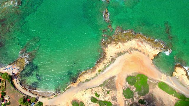 Slow motion bird's eye view of a beach in the city of Hersonissos on the Greek island of Crete. The waves in the sea move in slow motion.