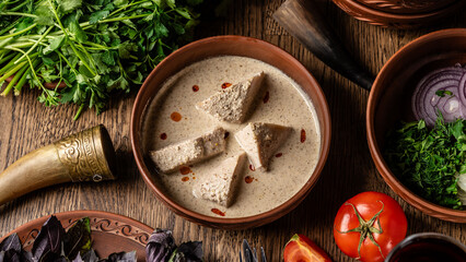 Georgian cuisine. Chicken fillet in a creamy sauce with Georgian spices, in a clay plate in a restaurant.
