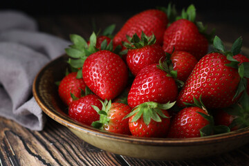 A bowl with ripe bright strawberry in rustic style