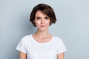 Obraz premium Photo of serious confident woman dressed white t-shirt smiling isolated grey color background