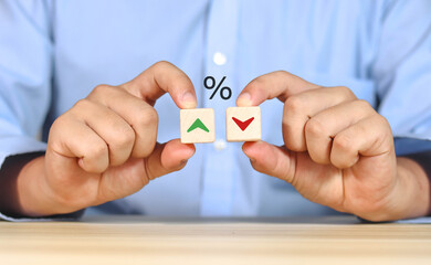 Financial interest rate holding wooden block with percentage sign and up arrow, financial growth,...