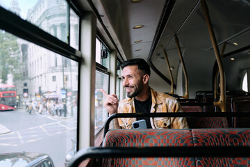 Smiling latin man looking out the bus window