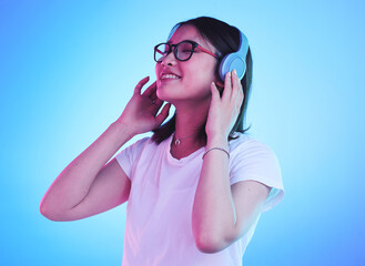 Young woman, student and headphones for listening, audio streaming and happy subscription on blue...