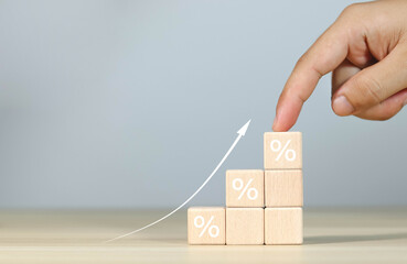 Financial interest rate holding wooden block with percentage sign and up arrow, financial growth,...