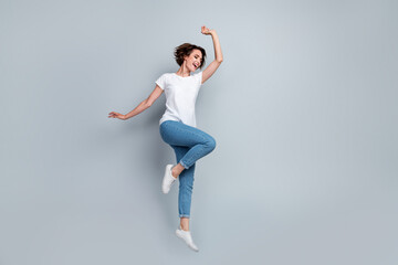 Full size photo of satisfied funny nice girl dressed white t-shirt denim jeans jumping having fun...