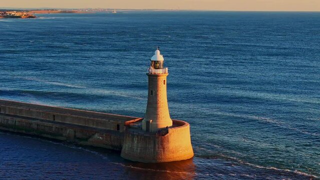 Orbital shot of North Pier lighthouse, Tynemouth at Sunrise during Golden Hour.