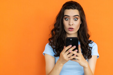 Photo of amazed woman hold telephone open mouth isolated orange color background