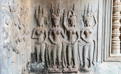 Wall carving with womans dancers apsara. Ancient ruins Angkor Wat temple - famous Cambodian...