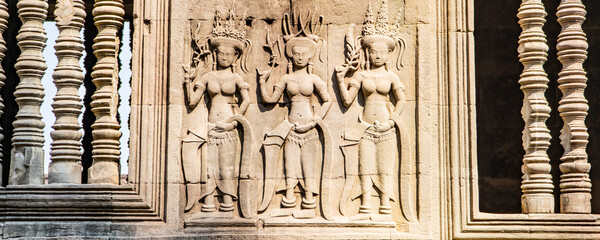 Wall carving with womans dancers apsara. Ancient ruins Angkor Wat temple - famous Cambodian landmark. Siem Reap, Cambodia.