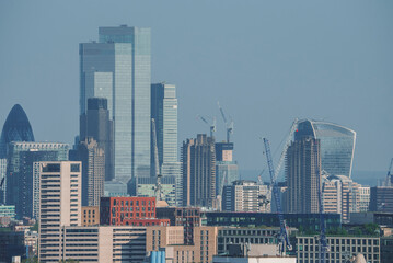 View of famous financial skyscrapers amidst residential district. Modern city with blue sky in background. High angle view of urban development in London.