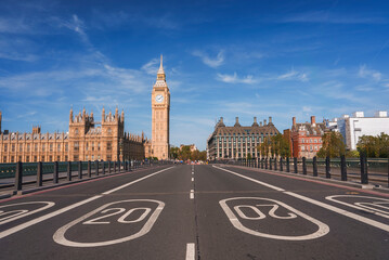 Empty road leading towards Big Ben and Westminster palace. Numbers and signs on bridge during sunny...