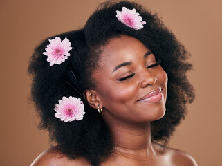 Hair care, flowers and black woman, happy and beauty in studio isolated on a brown background....