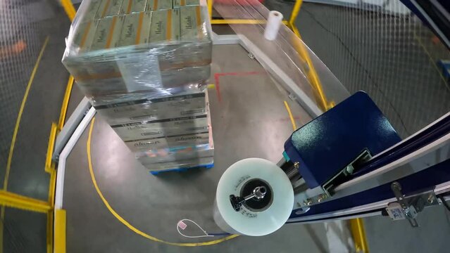 Box stretch wrapping machine timelapse. pallet wrapping machine. Machine for wrapping boxes in a plastic film in a circle. Packing boxes in plastic film.