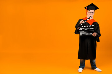 Smiling young man with down syndrome wearing glasses in graduation suit, place for text