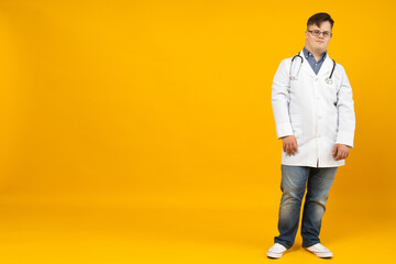 Smiling young man with down syndrome wearing glasses in doctor uniform with stethoscope, place for...