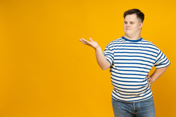 Smiling young man with down syndrome posing on orange background, place for text