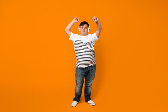 Smiling young man with down syndrome listening to music in headphones