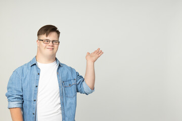Smiling young man with down syndrome wearing glasses in doctor uniform with stethoscope