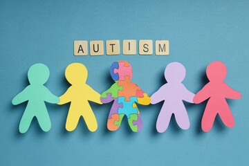 Paper figures of people on a light background. World autism day concept