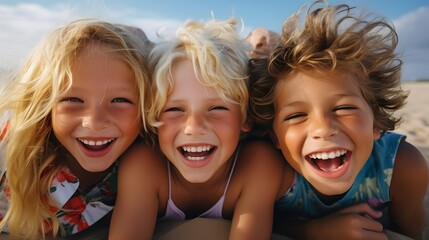 Fototapeta premium Portrait of three happy children smiling on the beach. 