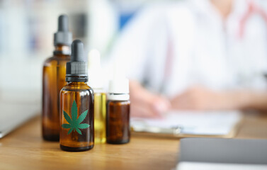 Vials of marijuana oil are on table in medical office. Prescribing marijuana for medicinal purposes concept