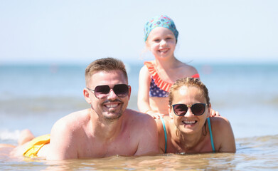 Obraz premium Married couple with child spend time at sea. Family travel to resorts concept