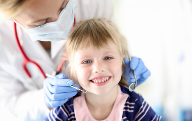 Portrait of smiling girl at dentist appointment. Treatment of baby milk teeth concept