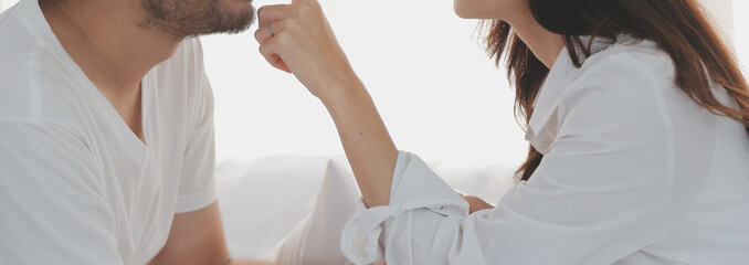 Obraz premium In love new couple at home.Cheerful beautiful young couple relexing on sofa home.Romantict moment.In selective focus. Setup studio shooting.