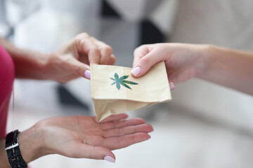 Handing over paper bag with marijuana sign. Marijuana delivery service concept