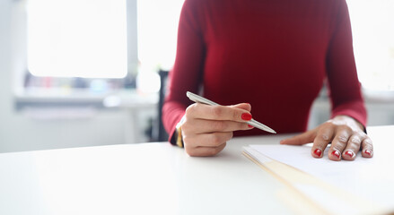 Woman holds pen in her hands and prepares to sign documents. Successful business agreement concept