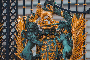 Closeup shot of lions on metal gate. Entrance of Buckingham Palace. Black and golden fence of famous kingdom in London. - obrazy, fototapety, plakaty