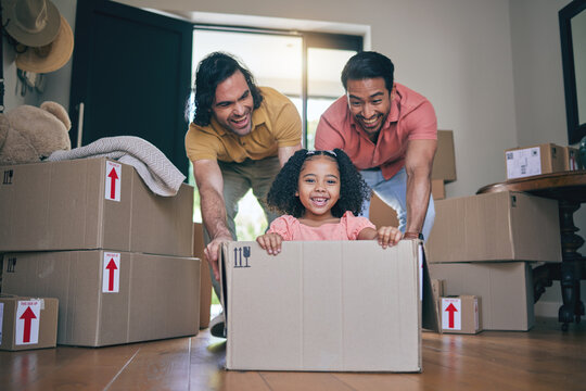 Happy, family fun and box moving with child and gay parents in new home with cardboard package. Dad smile, kid and lgbt people together with youth game and property love in a house helping father