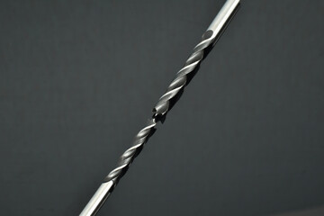 Locksmith tool. Two drills of the same diameter, length and purpose lie on a dark background.