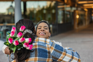 Fototapeta premium couple hug flowers gift in love, beautiful multiracial couple celebrating valentine's day together