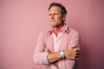 Lifestyle portrait photography of a man in his 40s scratching his arm due to atopic dermatitis wearing a chic cardigan against a pastel or soft colors background 