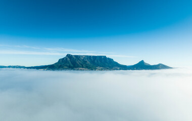 Cape Town's famous Table Mountain seen from above a thick bank of fog hanging over the city. 