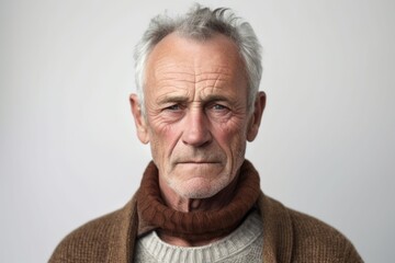 Fototapeta premium Medium shot portrait photography of a man in his 60s with furrowed brows and a tense expression due to hypertension wearing a chic cardigan against a white background 