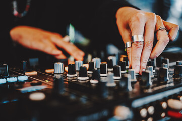 woman DJ Hands creating and regulating music on dj console mixer in concert