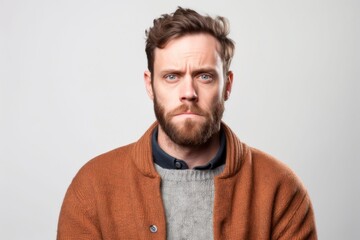 Fototapeta premium Medium shot portrait photography of a man in his 30s with a pained and tired expression due to fibromyalgia wearing a chic cardigan against a white background 